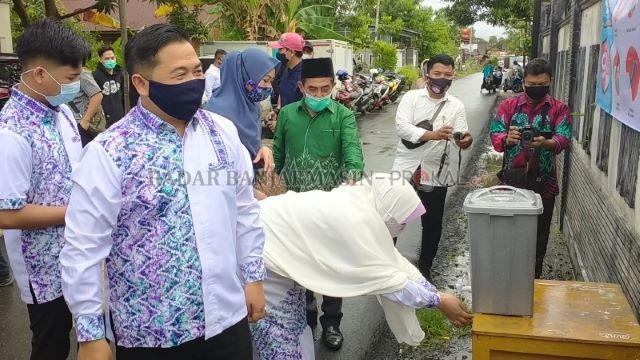 PROTOKOL: Sebelum memasuki TPS, Ibnu Sina dan istrinya Siti Wasilah mencuci tangan lebih dulu. | FOTO: ENDANG S/RADAR BANJARAMASIN
