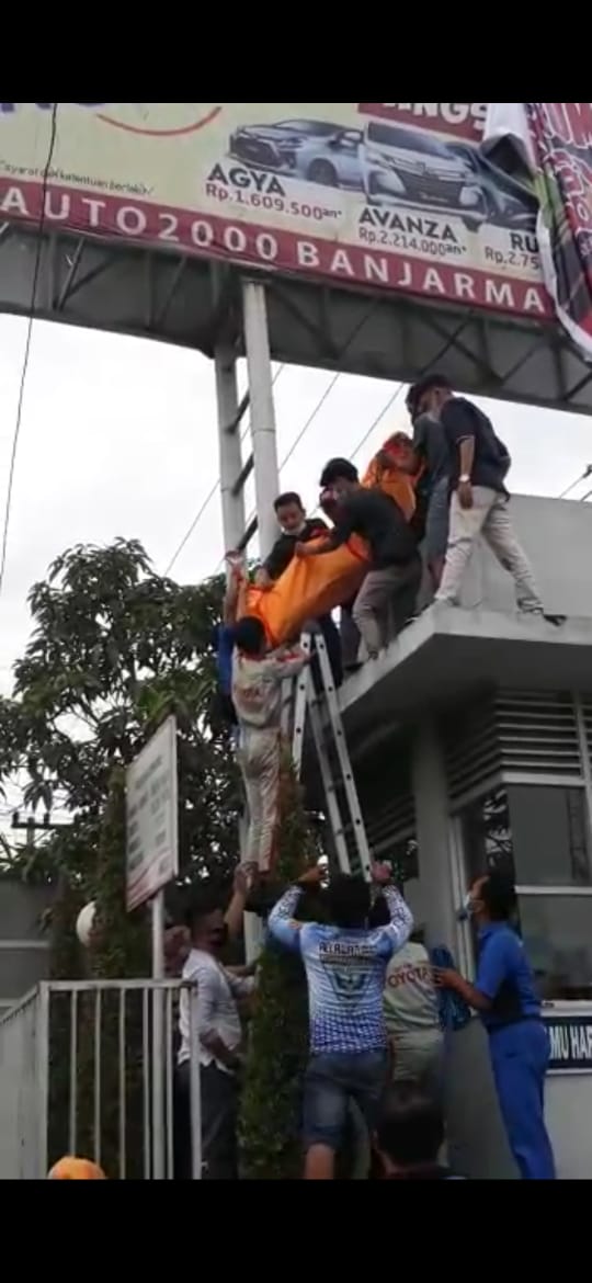 EVAKUASI: Relawan dari Landu Rescue berusaha mengevakuasi korban kesetrum dengan menggunakan kantong jenazah dari atas rangka baliho di Liang Anggang Jumat sore. | Foto: Landu Rescue for Radar Banjarmasin