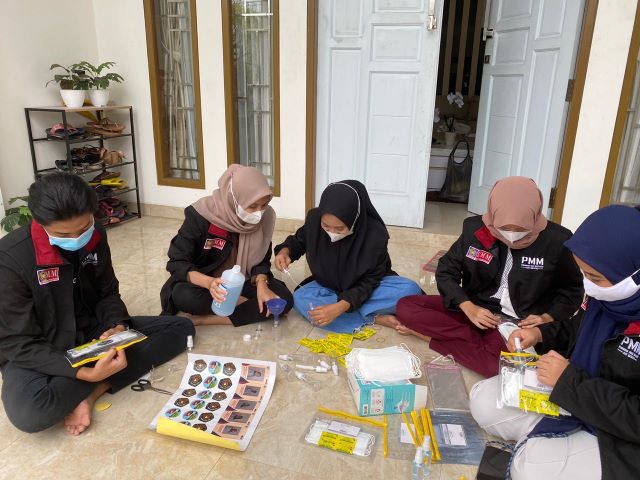 PENGABDIAN MASYARAKAT: Mahasiswa UMM yang menyiapkan starter kit vitamin C yang dibagikan di Kelurahan Sungai Bilu, Minggu (20/12) kemarin.