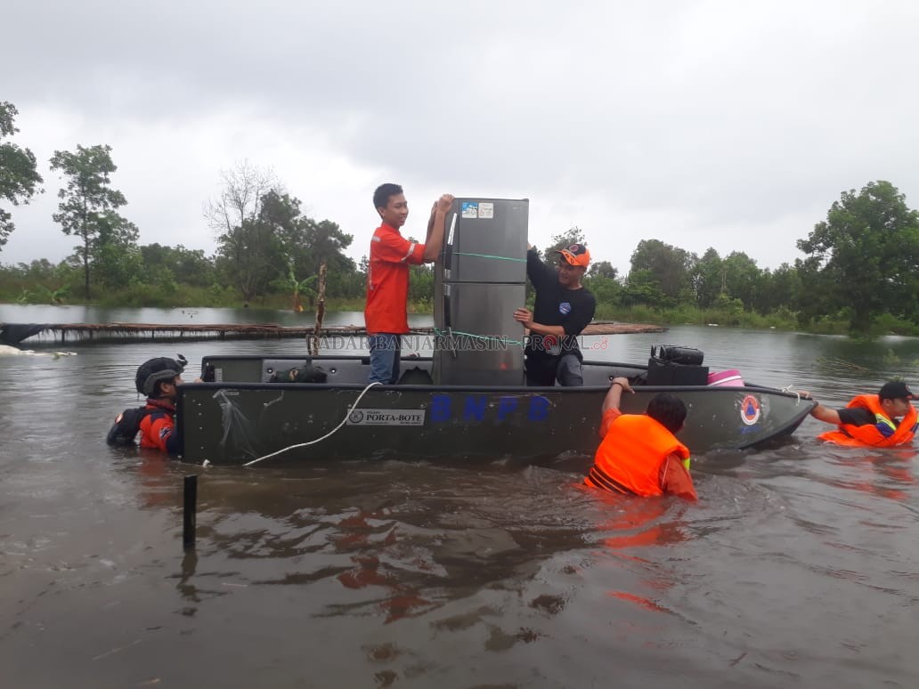 SELAMATKAN BARANG: Petugas BPBD Banjarbaru bersama relawan mengevakuasi barang berharga dari rumah warga yang tergenang banjir di kawasan Guntung Manggis. | Foto: BPBD Banjarbaru for Radar Banjarmasin