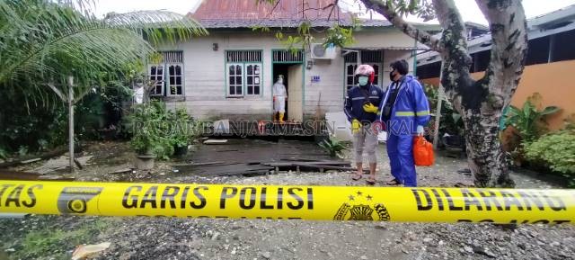 KONTRAKAN KORBAN: Rumah Bernadus diberi garis polisi. Mencegah warga berkerumun menonton. Tampak petugas puskesmas mengenakan APD lengkap. | FOTO: MAULANA/RADAR BANJARMASIN