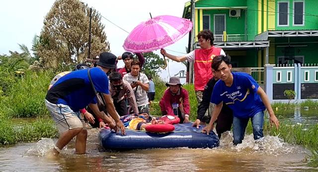 Di tengah genangan banjir seorang ibu hamil warga RT 52 jalur Pesona 15 Kompleks Persada Permai Baru 3 Desa Semangat Dalam, terpaksa dievakuasi, Rabu (20/1) siang ini.