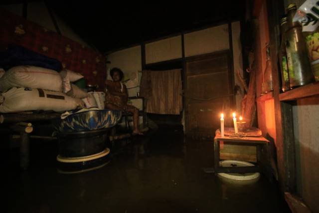 GELAP DAN BASAH: Sejunlah warga di Sungai Bakung, Kecamatan Sungai Tabuk, Kabupaten Banjar, memilih bertahan di rumah meski banjir menggenang. Sejumlah kawasan bak kota mati karena kondisi gelap gelita dan sepi aktivitas warga. | FOTO: MUHAMMAD RIFANI/RAD
