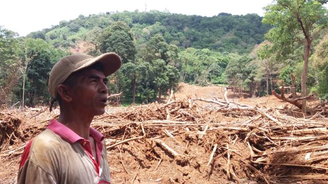 LONGSOR: Ahmad Suryani, warga Desa Tungkaran di depan sisa longsor yang terjadi di Gunung Keramaian.