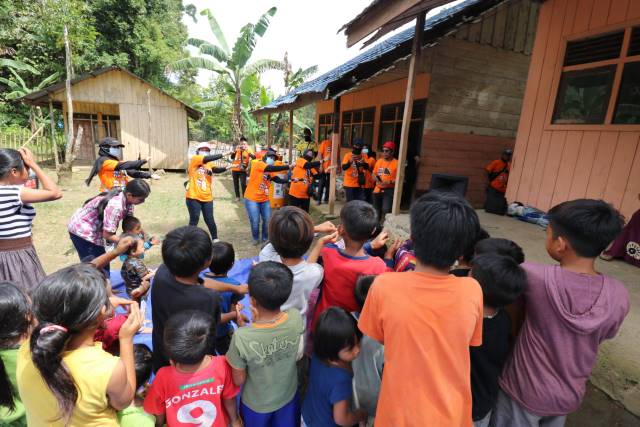 MISI LITERASI: Staf Dispersip saat menghibur anak-anak di Pegunungan Meratus. | FOTO: IST