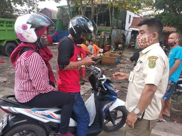 TERJARING: Satpol PP meminta kartu identitas dari warga yang kedapatan membuang sampah di siang bolong di TPS pertigaan Jalan Veteran. | FOTO: ENDANG SYARIFUDDIN/RADAR BANJARMASIN