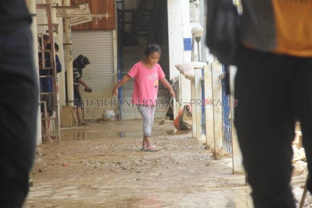 BAKAL DIBANTU: Seorang anak berjalan di atas lumpur akibat banjir di Pasar Murakata, Barabai, pertengahan Januari lalu. Pasar Murakata adalah salah dari tiga pasar yang rusak cukup parah di HST. | Foto: Dok/Radar Banjarmasin