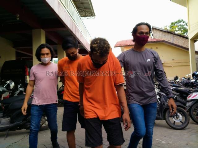 AKHIRNYA TERTANGKAP: Erfandi (di depan) dan Wahyu digiring polisi ke sel tahanan di Mapolresta Banjarmasin. | FOTO: MAULANA/RADAR BANJARMASIN