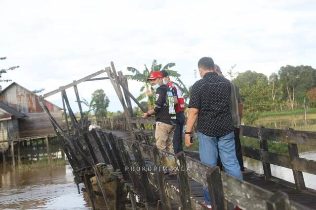MENINJAU JEMBATAN: Wakil Bupati Tanah Laut Abdi Rahman (topi merah) saat melakukan peninjauan jembatan di Desa Panjaratan, Minggu (7/3).