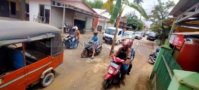RUSAK: Lubang jalan di salah satu titik kawasan Cemara ditanami warga dengan pohon pisang. \ FOTO: ENDANG SYARIFUDIN/RADAR BANJARMASIN