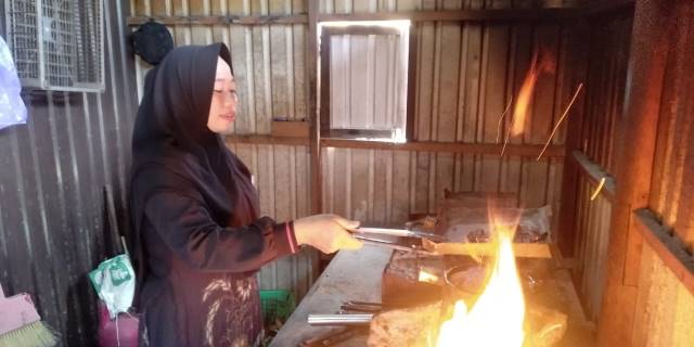 PROSES: Acil Nailah memanggang bingka tumis di tungku pembakaran. | Foto: Istimewa Radar Banjarmasin