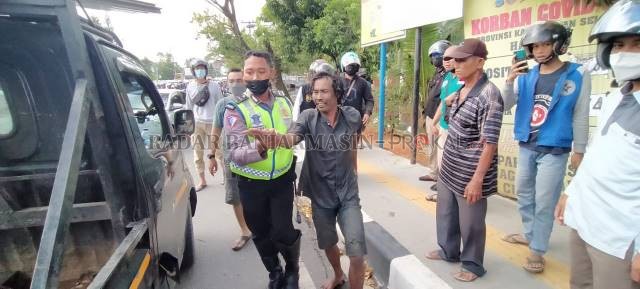 ADA-ADA SAJA: Basah kuyup dan berbau lumpur, Udin diamankan polantas yang kebetulan melintas. | FOTO: MAULANA/RADAR BANJARMASIN
