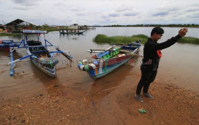 BEKAS GALIAN TAMBANG: Seorang pengunjung Danau Caramin berswafoto dengan latar belakang lanskap danau ketika sebelum pandemi lalu. Danau Caramin salah satu danau yang direncanakan diharapkan Pemko bisa jadi embung penampung limpasan air dalam upaya mitiga