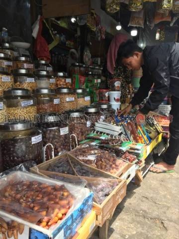 19 JENIS: Ridho (22) sedang menyusun kurma dagangannya. Di tokonya terdapat setidaknya 19 jenis kurma. | FOTO: TIA LALITA NOVITRI/RADAR BANJARMASIN
