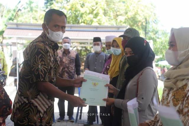 SERTIFIKAT PTSL: Bupati Tanah Laut HM Sukamta saat menyerahkan sertifikat PTSL kepada warga Desa Galam.