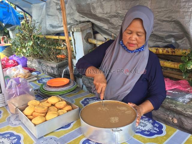 BERDAGANG: Gusti Halimatus (55) tengah memotong kue basah khas ramadan yang ia jual di lapaknya. | FOTO: TIA LALITA NOVITRI/RADAR BANJARMASIN