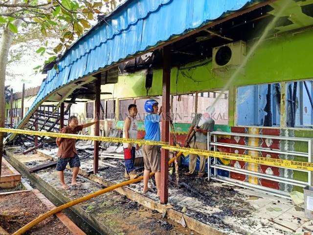 HANGUS: UPT Damkar Batola memadamkan kembali percikan bara api yang masih ada di SMA Negeri 1 Marabahan. | FOTO: AHMAD MUBARAK/RADAR BANJARMASIN