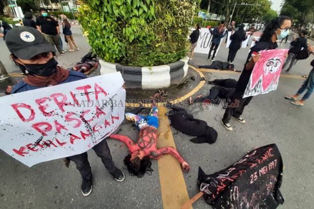 JUMAT KELABU: Aksi teatrikal peringatan kerusuhan 23 Mei 1997 dari aktivis Sanggar Titian Berantai Uniska, (23/5) sore di perempatan Jalan Lambung Mangkurat. | FOTO: WAHYU RAMADHAN/RADAR BANJARMASIN