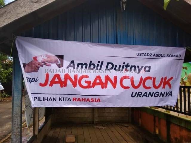 MARAK: Spanduk yang bertuliskan “ambil uangnya jangan cucuk urangnya” yang beredar di Banjarmasin. | FOTO: DOK/RADAR BANJARMASIN