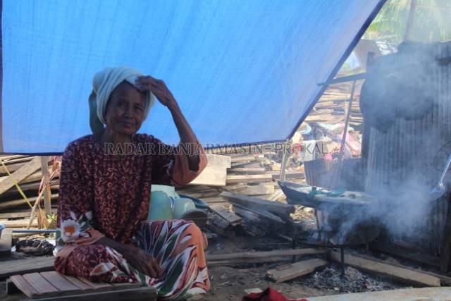 TAK LAYAK: Seorang nenek di Desa Waki Kecamatan Batu Benawa memasak di dapur sederhananya setelah rumahnya disapu banjir bulan Januari lalu. | FOTO: JAMALUDDIN/RADAR BANJARMASIN