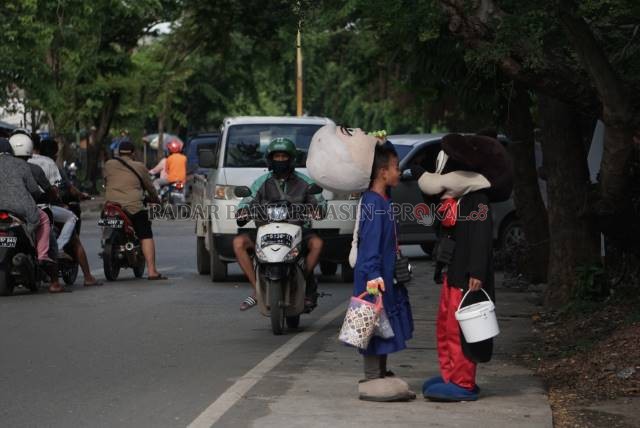 KASIHAN: Bocah di balik kostum badut dipotret beberapa waktu lalu di kawasan Teluk Tiram. | FOTO: WAHYU RAMADHAN/ RADAR BANJARMASIN