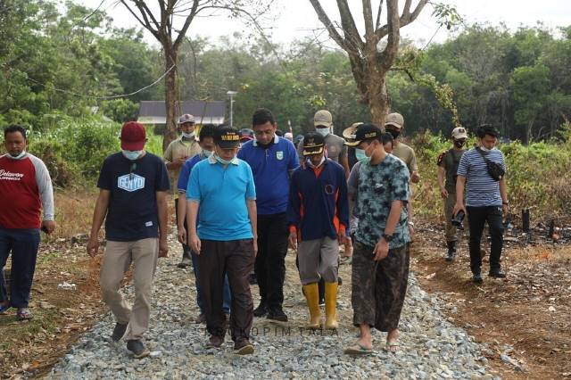 JALAN: Wakil Bupati Tanah Laut Abdi Rahman bersama warga melakukan pemeriksaan kegiatan gotong royong pengerasan jalan.