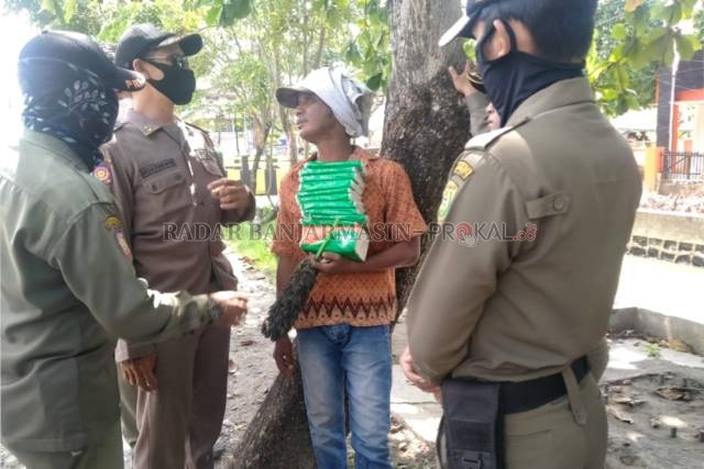 RAZIA: Pedagang tisu di perempatan lampu merah yang dicegat Satpol PP Banjarmasin, kemarin (17/6).