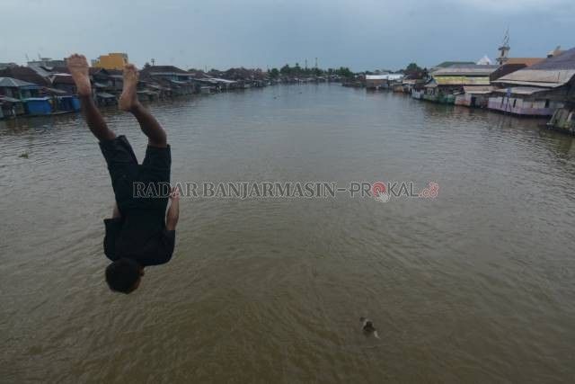 ANAK SUNGAI: Anak-anak dari kampung Pasar Lama terjun dan bercebur ke Sungai Martapura, kemarin (20/6). Kalau tak di Jembatan 9 November, mereka berkumpul di Jembatan Dewi. | FOTO: WAHYU RAMADHAN/RADAR BANJARMASIN