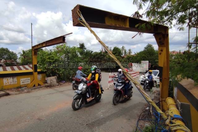 PATAH DUA: Portal baja di Jembatan Alalak II, penghubung antara Banjarmasin Utara dan Handil Bakti, dipotret (22/6). Dibiarkan patah dan menggantung, portal ini membahayakan bagi pengendara yang melintas di bawahnya.