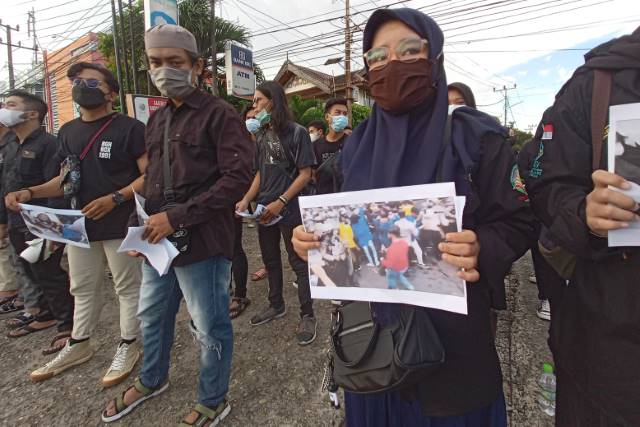 SOLIDARITAS: Mahasiswa menunjukkan foto-foto pemukulan mahasiswa kepada pengendara yang melintas di depan kampus UIN. | FOTO: BEM UIN ANTASARI FOR RADAR BANJARMASIN