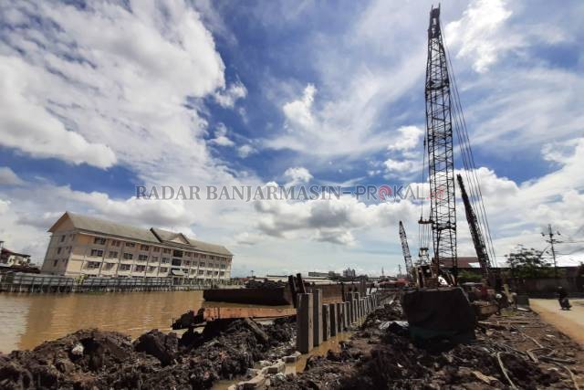 DIGENJOT LAGI: Proyek siring di tepian Sungai Martapura dengan latar Rusunawa Muara Kelayan dipotret kemarin (29/6) siang.
