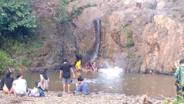 MEMUKAU: Wisatawan menikmati alam yang asri di air terjun Pal 20 Simpang Empat, Tanbu. Walau destinasi wisata ini belum masuk objek pemerintah, namun warga sudah ramai datang ke sana.