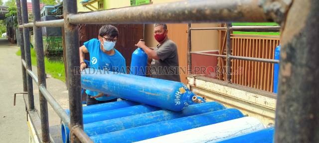 LARIS MANIS: Dua orang karyawan UD HMR memuat tabung oksigen untuk diantar ke rumah sakit di Pelaihari, Tanah Laut (Tala).