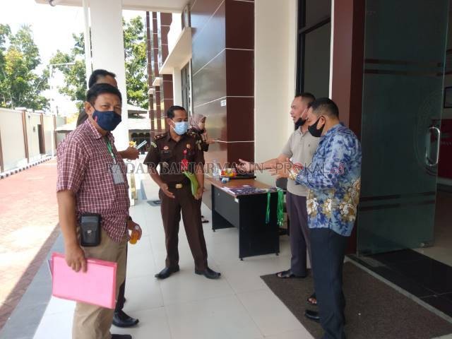 DITUNDA LAGI: Tim kuasa hukum Antung Nimatunzaidah berbincang dengan penyidik Kejaksaan Negeri HST usai keluar dari ruang persidangan di Pengadilan Negeri Barabai, Senin (5/7) pagi. | FOTO: JAMALUDDIN