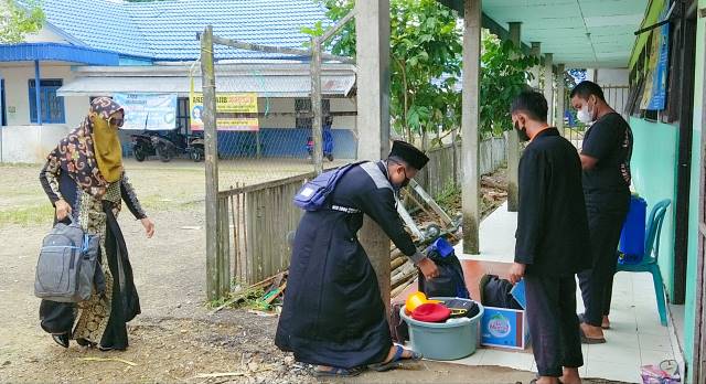 DISEMPROT DULU: Sebelum masuk ponpes, kelengkapan santri wajib melalui tahapan penyemprotan disinfektan.
