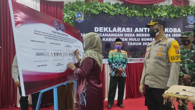 KOMITMEN BERSAMA: Kepala BNNK HSS, Agus Winarti menandatangani komitmen bersama saat deklarasi anti narkoba dan pencanangan Desa Bersinar | FOTO: SALAHUDIN/RADAR BANJARMASIN