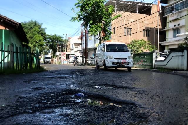 ASPAL TERKELUPAS: Salah satu titik kerusakan terparah di depan gedung milik Kanwil Kemenag Kalsel. | FOTO: WAHYU RAMADHAN/RADAR BANJARMASIN
