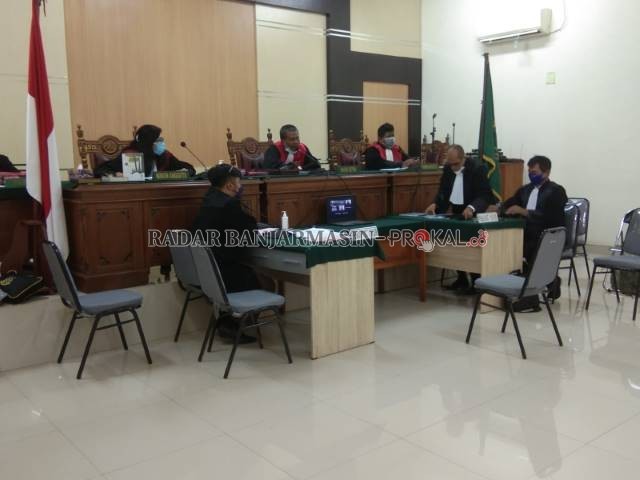 SIDANG DARING: Dari sebuah komputer jinjing di tengah ruang sidang, Jurkani mengikuti jalan persidangan beberapa waktu yang lalu. | FOTO: ENDANG SYARIFUDDIN/RADAR BANJARMASIN