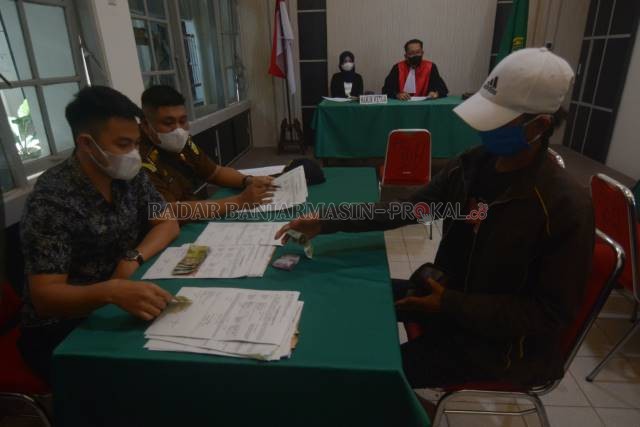BAYAR DENDA: Begitu terjaring operasi yustisi, pelanggar prokes langsung disidang. Ada yang didenda hakim, ada pula yang divonis kerja sosial. | FOTO: WAHYU RAMADHAN/RADAR BANJARMASIN