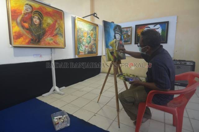 PERUPA: Kris Imanu menyelesaikan lukisannya di Gedung Wargasari, Taman Budaya Kalsel di Jalan Hasan Basri, kemarin (13/8). | FOTO: WAHYU RAMADHAN/RADAR BANJARMASIN