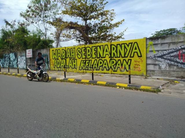 SUARA KRITIS: Mural di Jalan RE Martadinata, kawasan eks Pelabuhan Marla, dipotret kemarin (17/8) siang. Semoga mural sindiran itu tak ditanggapi secara reaktif dan berlebihan. | FOTO: ENDANG SYARIFUDDIN/RADAR BANJARMASIN