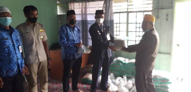 PEDULI: Kadinsos Tanah Bumbu Basuni menyerahkan santunan dari pemerintah daerah kepada puluhan veteran.