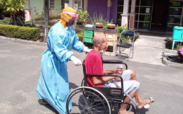 MASIH GAWAT: Tenaga kesehatan saat mengantar lansia di Panti Sosial Tresna Werdha (PSTW) Budi Sejahtera usai dinyatakan negatif. Dua pekan terakhir sudah ada tujuh lansia di tempat ini yang meninggal dunia, akibat virus corona. | FOTO: PSTW BUDI SEJAHTERA