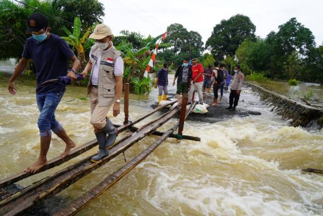 GERAK CEPAT: Sekda Pemkab Tanbu Ambo Sakka meninjau banjir di Lasung yang kembali meluap akibat intensitas curah hujan tinggi.