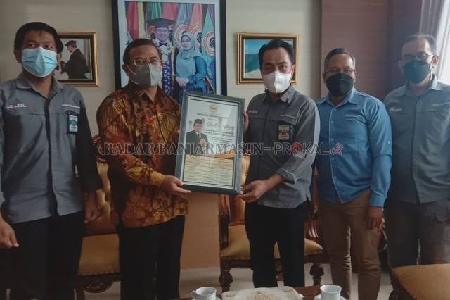 KUNJUNGAN: Rektor ULM, Prof Sutarto Hadi menerima cinderamata dari Direktur Radar Banjarmasin, H Suriansyah Achmad. Pertemuan berlangsung santai. | Foto: FAUZAN RIDHANI/RADAR BANJARMASIN