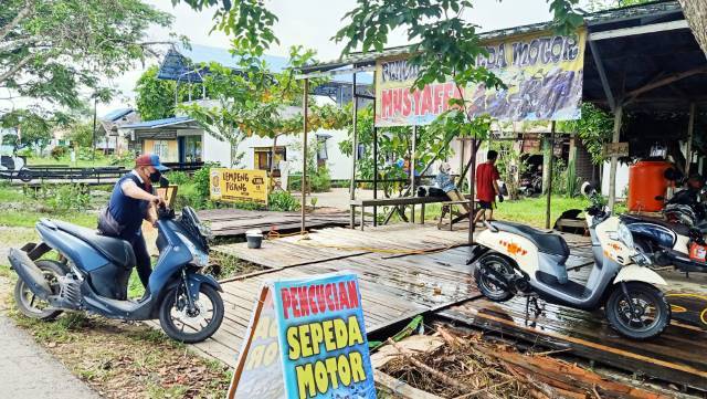 ANTAR JEMPUT: Iwang secara langsung membawa motor yang ingin di cuci dari rumah pelanggan ke tempat pencuciannya yang berada di Jalan Jenderal Sudirman Marabahan. | Foto: Ahmad Mubarak/Radar Banjarmasin