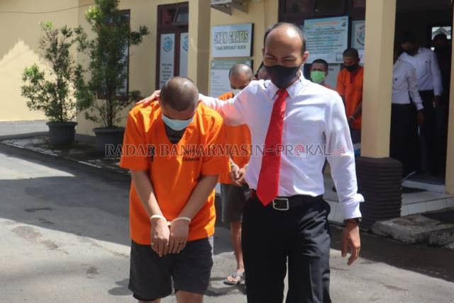 TERTUNDUK: Anggota Sat Narkoba Polres Tapin membawa pelaku kejahatan narkoba ke sel tahanan. | FOTO: RASIDI FADLI/RADAR BANJARMASIN