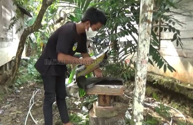 PANEN MADU : Nurman memanen madu kelulut hasil usahanya sendiri. Dia bermimpi mengembangkan usahanya lebih besar lagi.  | FOTO: IBNU DWI WAHYUDI/RADAR BANJARMASIN