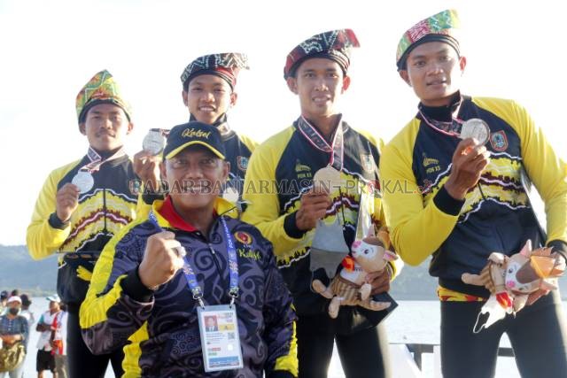 POSE JUARA: Ketua KONI Kalsel Bambang Heri Purnama bersama para peraih medali cabor dayung nomor kayak 4 putra di podium venue Teluk Youtefa, Kota Jayapura, kemarin (29/9) sore.