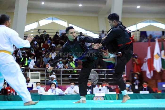 KEJAR POIN: Pesilat Kalsel Muhammad Azhar Aridha berusaha mengejar ketertinggalan poin di babak ketiga saat berduel dengan Rikki Munandar dari Sulawesi Tenggara di GOR Toware, Kwadeware, kemarin (8/10) siang. | FOTO: M IDRIS JIAN SIDIK / RADAR BANJARMASIN